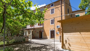 A two-story building with a balcony, a wooden fence, and a clear sky.