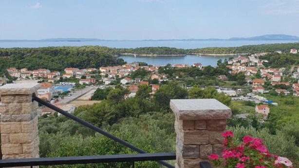 Uma vila costeira com vista para o mar, casas e vegetação.
