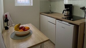 Une cuisine compacte équipée d’un évier, d’une machine à café et d’un petit réfrigérateur.
