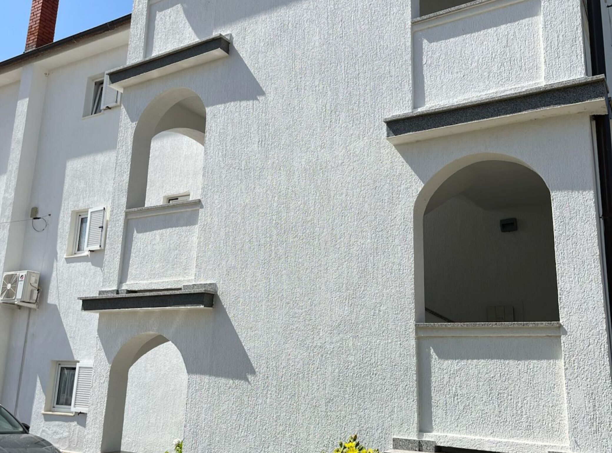 A building with white exterior walls, multiple windows, and a visible chimney.