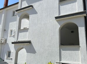 A building with white exterior walls, multiple windows, and a visible chimney.