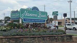 Navarre Beach -kyltti, jossa on ystävällinen tervehdys ja kuvaus alueesta Floridan rennoimpana lomakohteena.