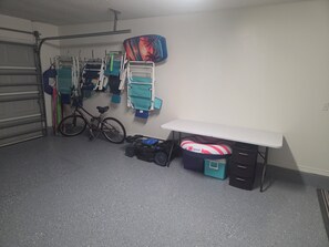 Een kamer met een fiets, een bureau en opbergruimte.