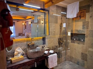 A bathroom with a stone sink, a glass shower enclosure, and a wooden vanity. - Casa Laja - Hotel Boutique (San Miguel de Allende)