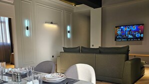 Departamento, 1 habitación, vista a la ciudad | Área de sala de estar | Smart TV de 90 cm con canales por cable 
