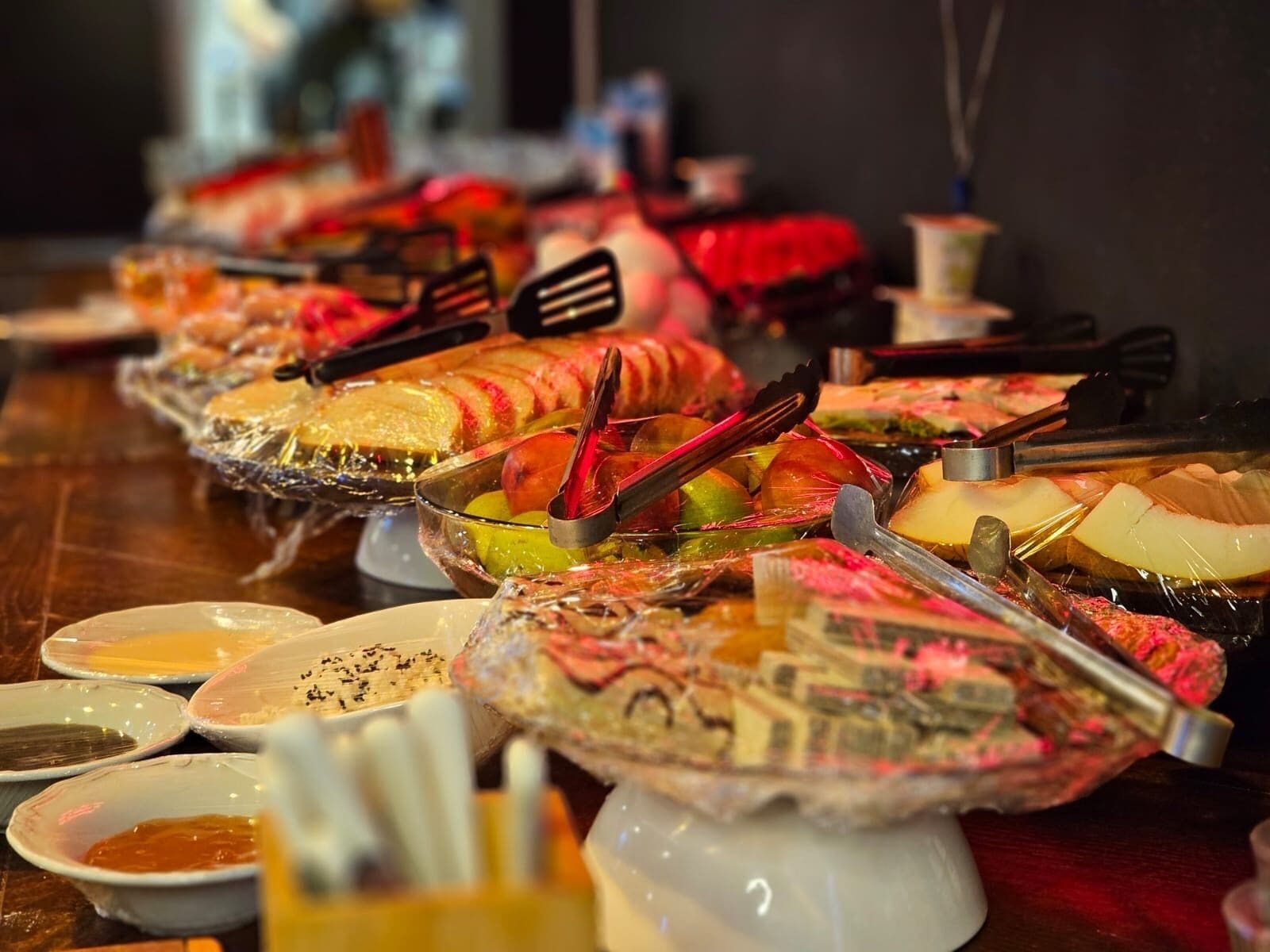 A buffet with various food items and serving utensils.
