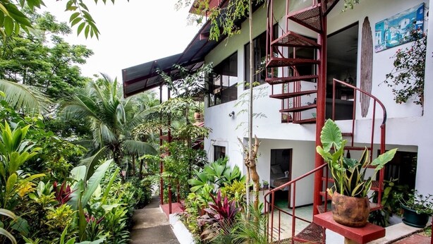 A multi-level building with a spiral staircase, surrounded by lush tropical vegetation. - Cozy 1-bedroom apartment with AC in tranquil Quepos (Quepos)