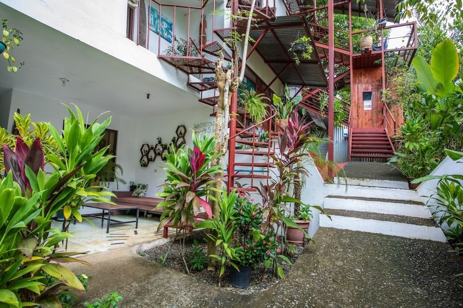 A multi-level outdoor garden with a spiral staircase, seating areas, and various plants.