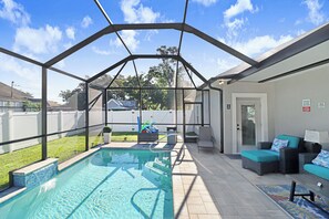 Piscina exterior coberta com área de terraço, incluindo assentos e um contentor de lixo.