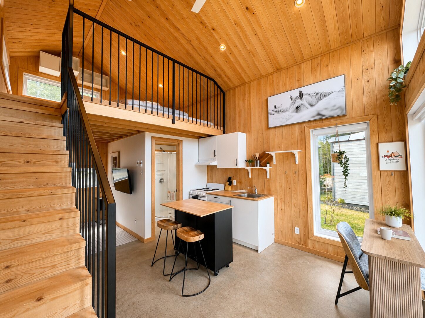 Un intérieur en bois comprenant une cuisine, un coin repas et un escalier.