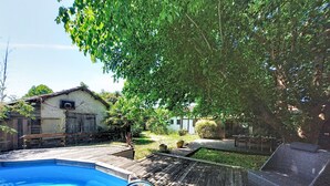 A swimming pool with a wooden deck, a basketball hoop, and a house in the background. - La landaise by Interhome (Saint-Vincent-de-Tyrosse)