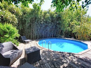 A swimming pool with a wooden deck and lounge chairs. - La landaise by Interhome (Saint-Vincent-de-Tyrosse)