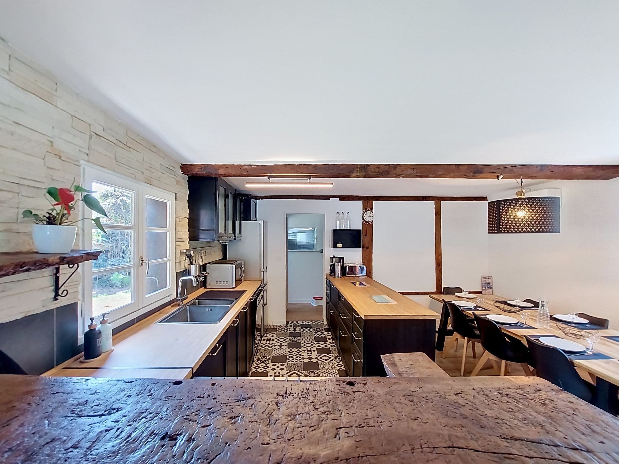 A kitchen with a wooden table, a sink, and a refrigerator.