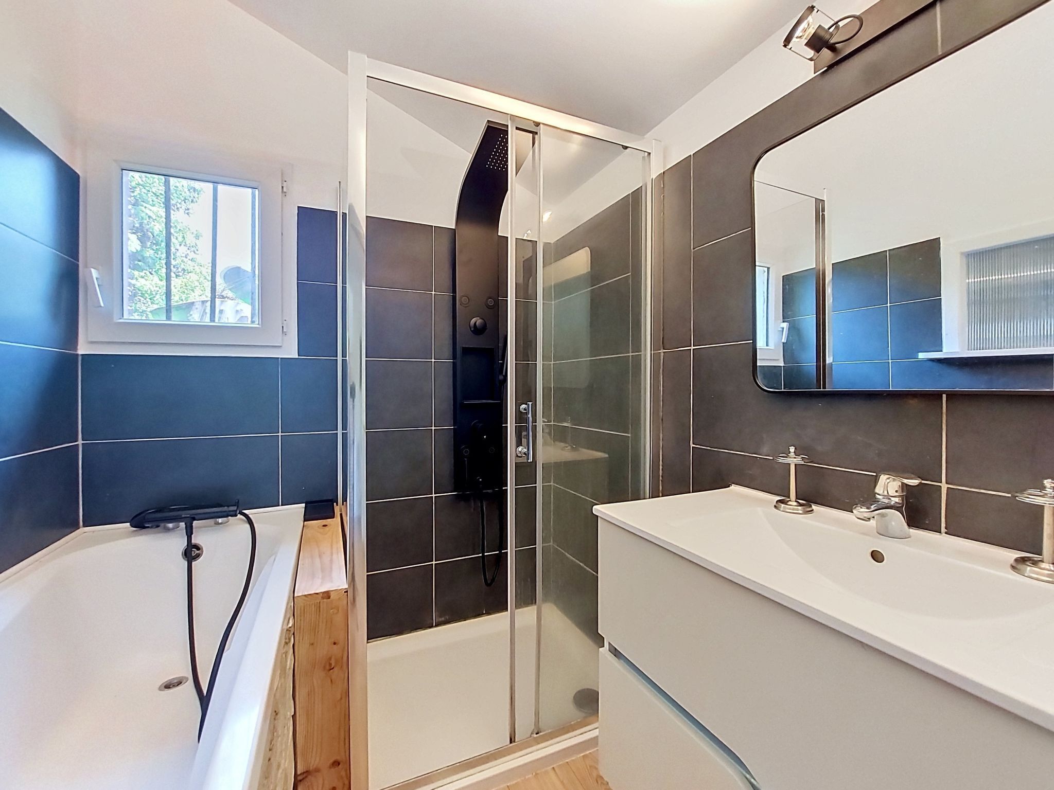 Uma casa de banho moderna com banheira, chuveiro e toucador.