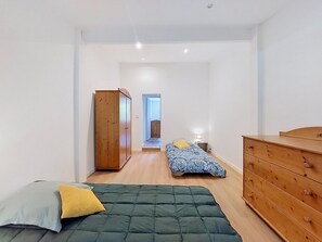 Ein Schlafzimmer mit einem Bett, einem Schminktisch, einem Kleiderschrank und einem Nachttisch.