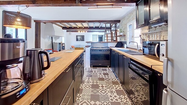 A modern kitchen with a central island, built-in appliances, and patterned flooring. - La landaise by Interhome (Saint-Vincent-de-Tyrosse)