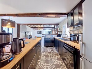 Een moderne keuken met een centraal eiland, inbouwapparatuur en een vloer met een patroon.