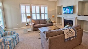 Ein Wohnzimmer mit Kamin, Fernseher und zwei Sofas.