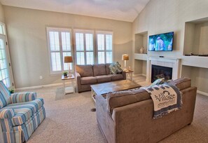 A living room with a fireplace, a television, and two couches. - Bear Trap Dunes resort 3BR Luxury Golf Villa 53F (Ocean View)