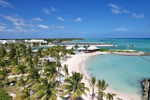 Ein Strandresort mit Palmen, einem Sandstrand und einem klaren, blauen Meer.