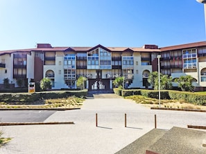 Ein mehrstöckiges Hotel mit zentralem Eingang, Balkonen und einem angelegten Innenhof.