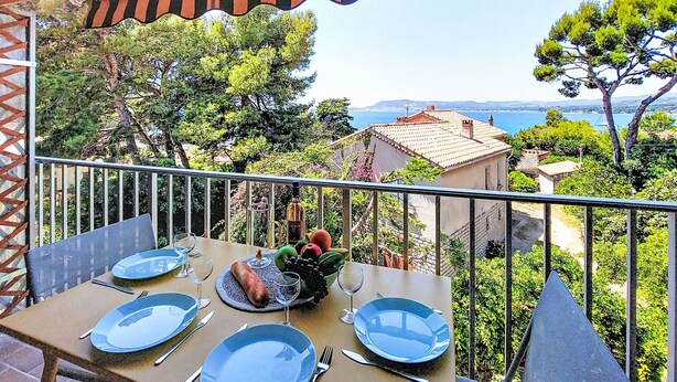 A balcony with a table set for four, overlooking a coastal landscape. - Les Aigues Marines by Interhome (Saint Cyr sur Mer La Madrague)