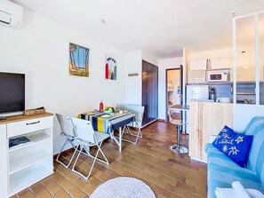 A compact living space with a dining area, kitchenette, and a TV. - Les Aigues Marines by Interhome (Saint Cyr sur Mer La Madrague)