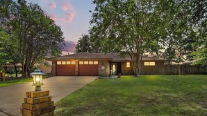 A residential house with a garage, a well-maintained lawn, and a street lamp. - Toledo Bend Lake House: Peaceful Retreat with Direct Waterfront Access (Hemphill)