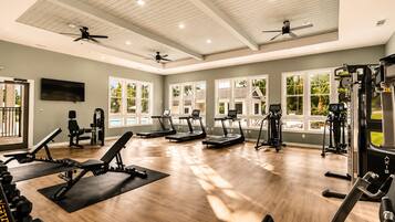 A gym with treadmills, weight machines, and a ceiling fan.