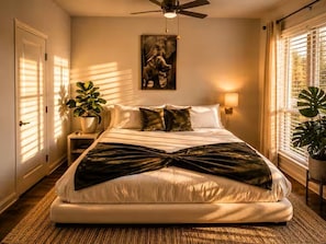 A bedroom with a bed, a ceiling fan, a wall-mounted light, and a window with blinds. - Modern Lakeview Oasis, King Bed • Gym • Pool (Jacksonville)