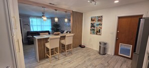 Eine moderne Küche mit Barbereich, Holzboden und einem Mülleimer.