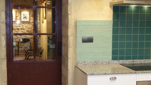 A kitchen with a stone arch doorway, a tiled backsplash, and a built-in oven. - Ideal for a group of 4 families, between two natural parks, the sea and Port Aventura. (Camarles)