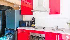 Uma cozinha compacta com máquina de lavar, cafeteira e micro-ondas.