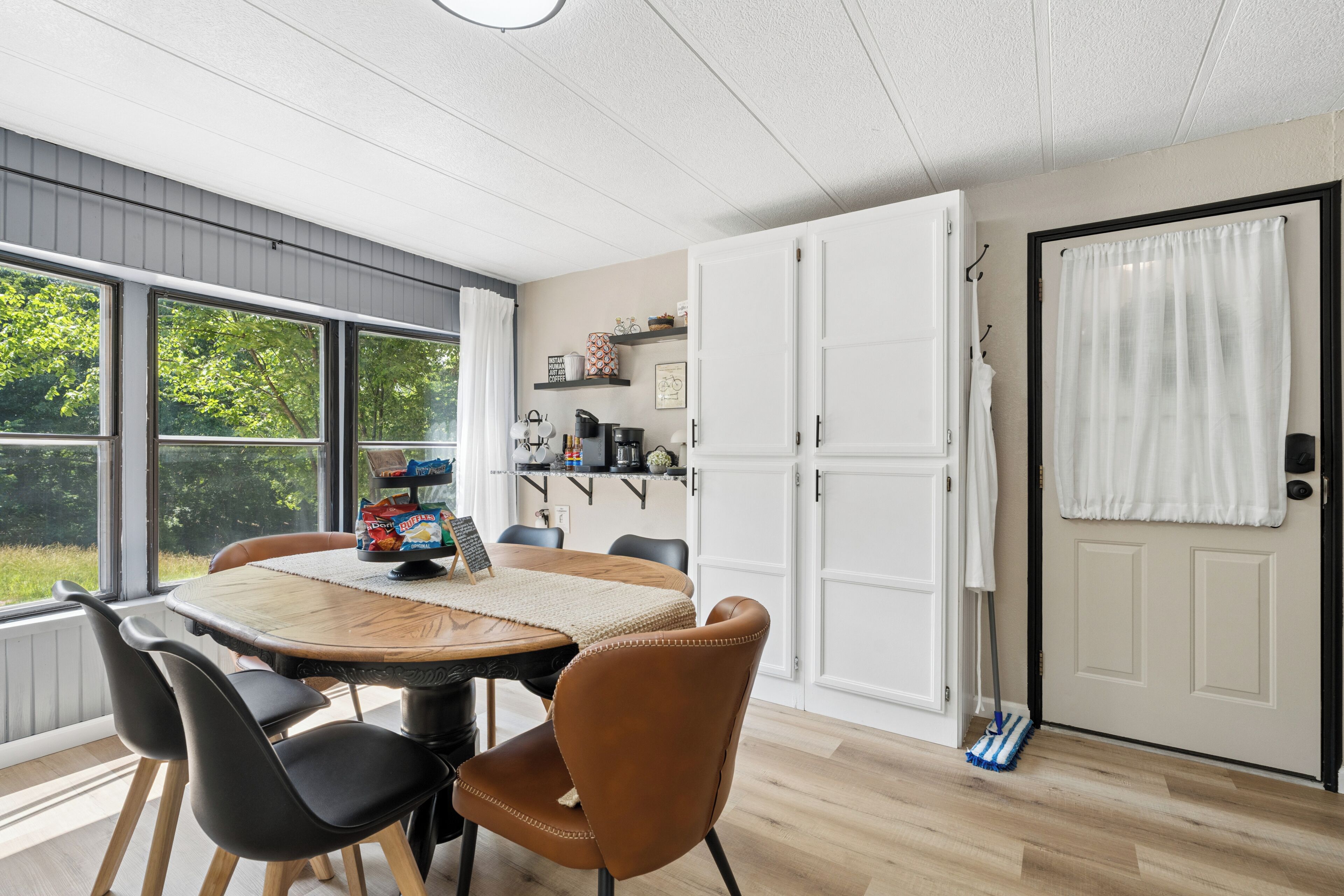 Een eethoek met een tafel, stoelen en uitzicht op de omgeving.