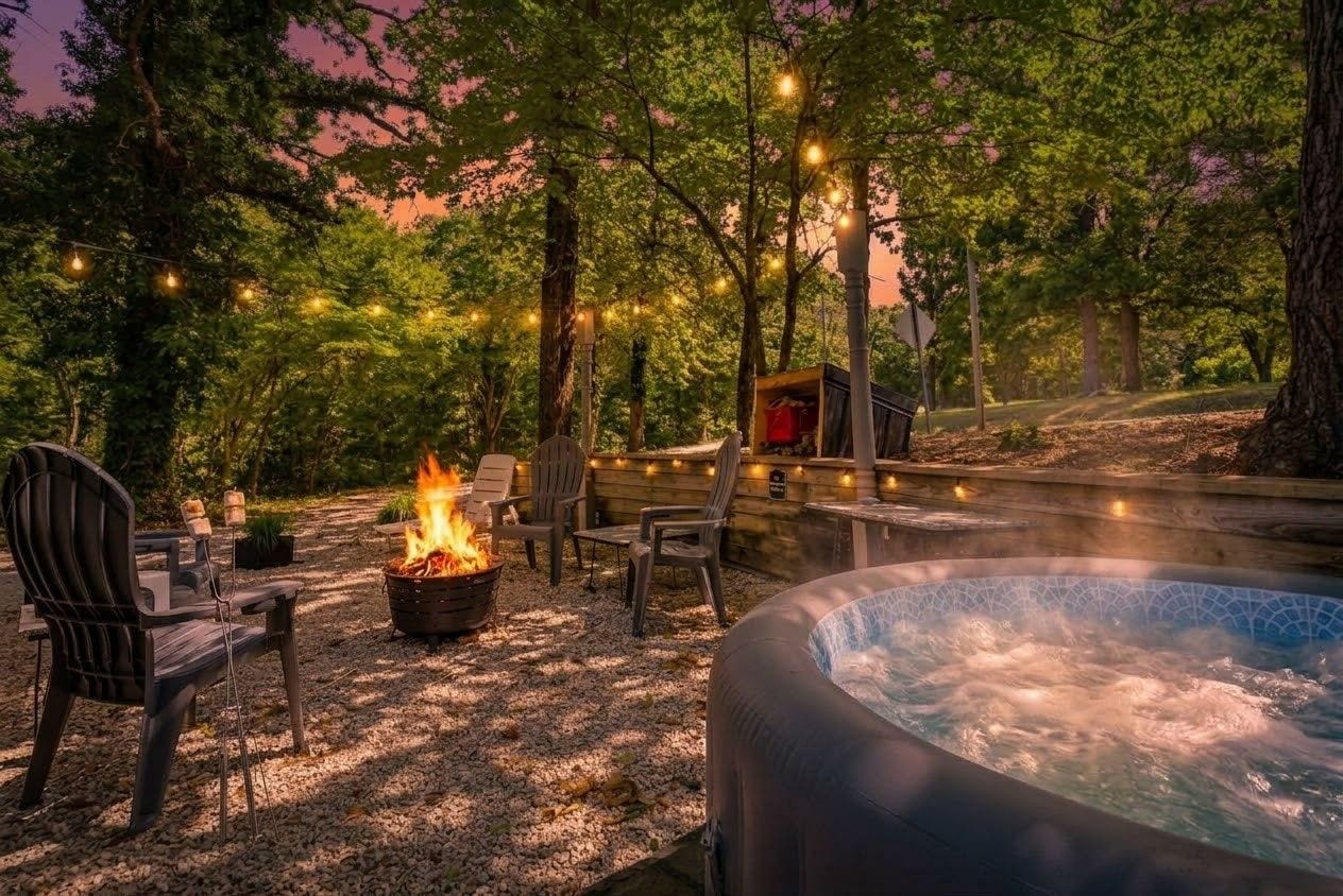 An outdoor hot tub area with seating and a fire pit.