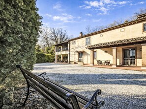 A two-story building with a patio area, outdoor seating, and a gravel driveway. - Le More by Interhome (Penna in Teverina)