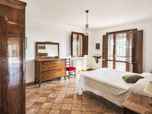 A bedroom with a bed, dresser, chair, and a window with a view. - Le More by Interhome (Penna in Teverina)