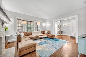 A modern living room with a sectional sofa, a coffee table, and a patterned rug. - 9 BR Movie Theater Duplex Near Cleveland Clinic! (Cleveland)