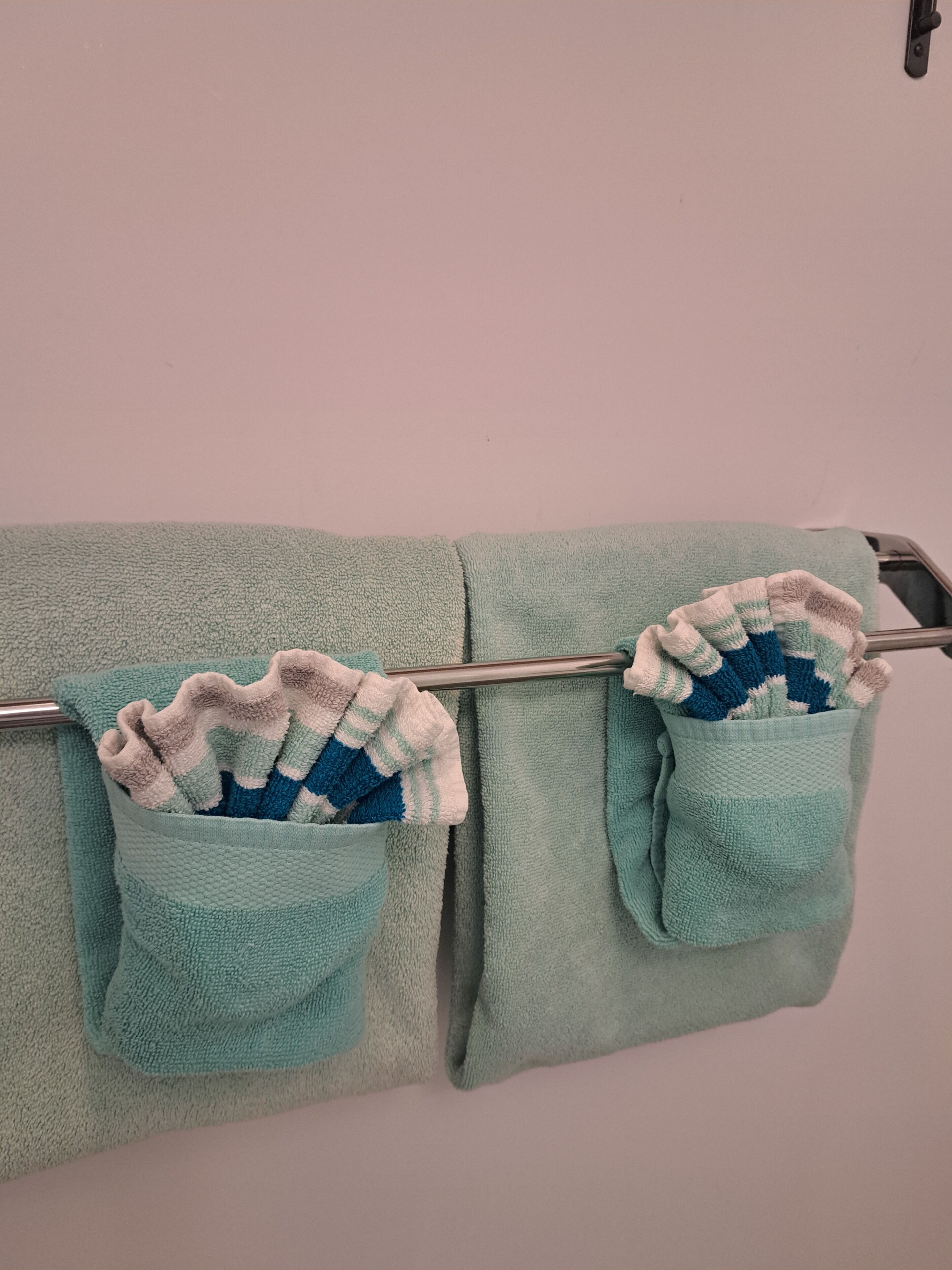 Une salle de bain avec un porte-serviettes sur lequel sont posées deux serviettes.