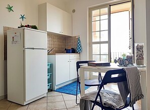 Une cuisine compacte équipée d’un réfrigérateur, de placards et d’une fenêtre donnant sur un beau paysage.