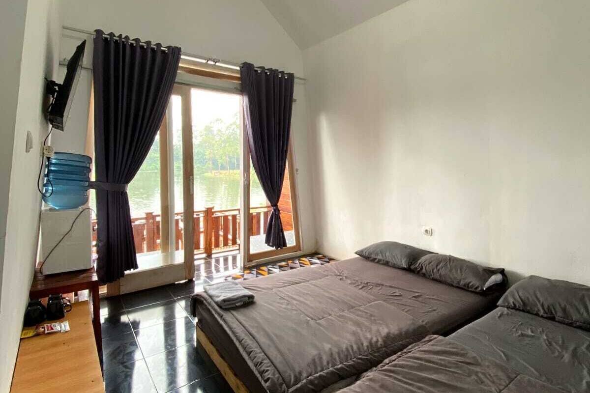 A room with a bed, a desk, a chair, and a window with curtains.