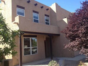 A two-story building with a flat roof, large windows, and a covered entrance. - Allegro Way (Albuquerque)