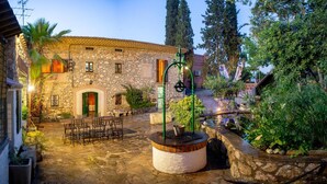 A stone building with a courtyard, outdoor seating, and a water feature.