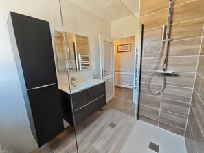 A modern bathroom with a glass shower enclosure, a vanity with a mirror, and a door leading to another room. - Castel Ar Vugale - Family home with sea view (Plouénan)