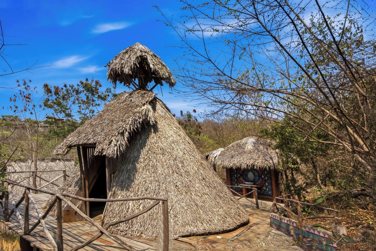 Thatched-roof huts with wooden walkways.