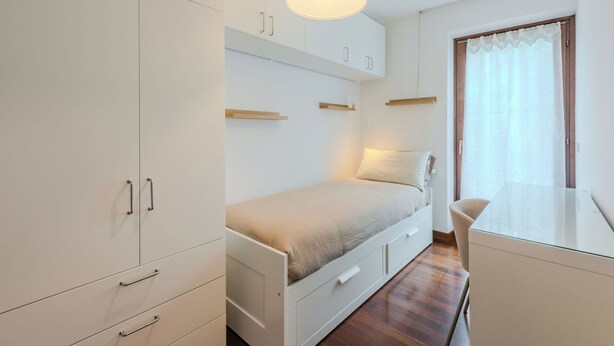Une chambre à coucher avec un lit, un bureau et une armoire.