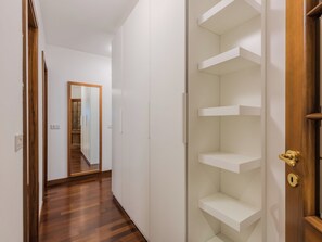 Ein Korridor mit Holzboden, weißen Wänden und einer Spiegeltür zu einem Schrank.