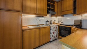 Une cuisine avec des meubles en bois, un évier en acier inoxydable, un four à micro-ondes et une cuisinière.