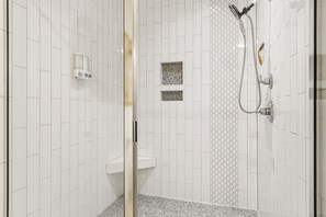 A shower with a handheld showerhead and a wall-mounted faucet, a soap dispenser, and a small shelf. - 3BD/2BA Gem .5 Miles from Cherrydale -  2 King Beds (Greenville)