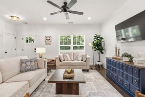 A living room with a sofa, coffee table, TV, and a cabinet. - 3BD/2BA Gem .5 Miles from Cherrydale -  2 King Beds (Greenville)
